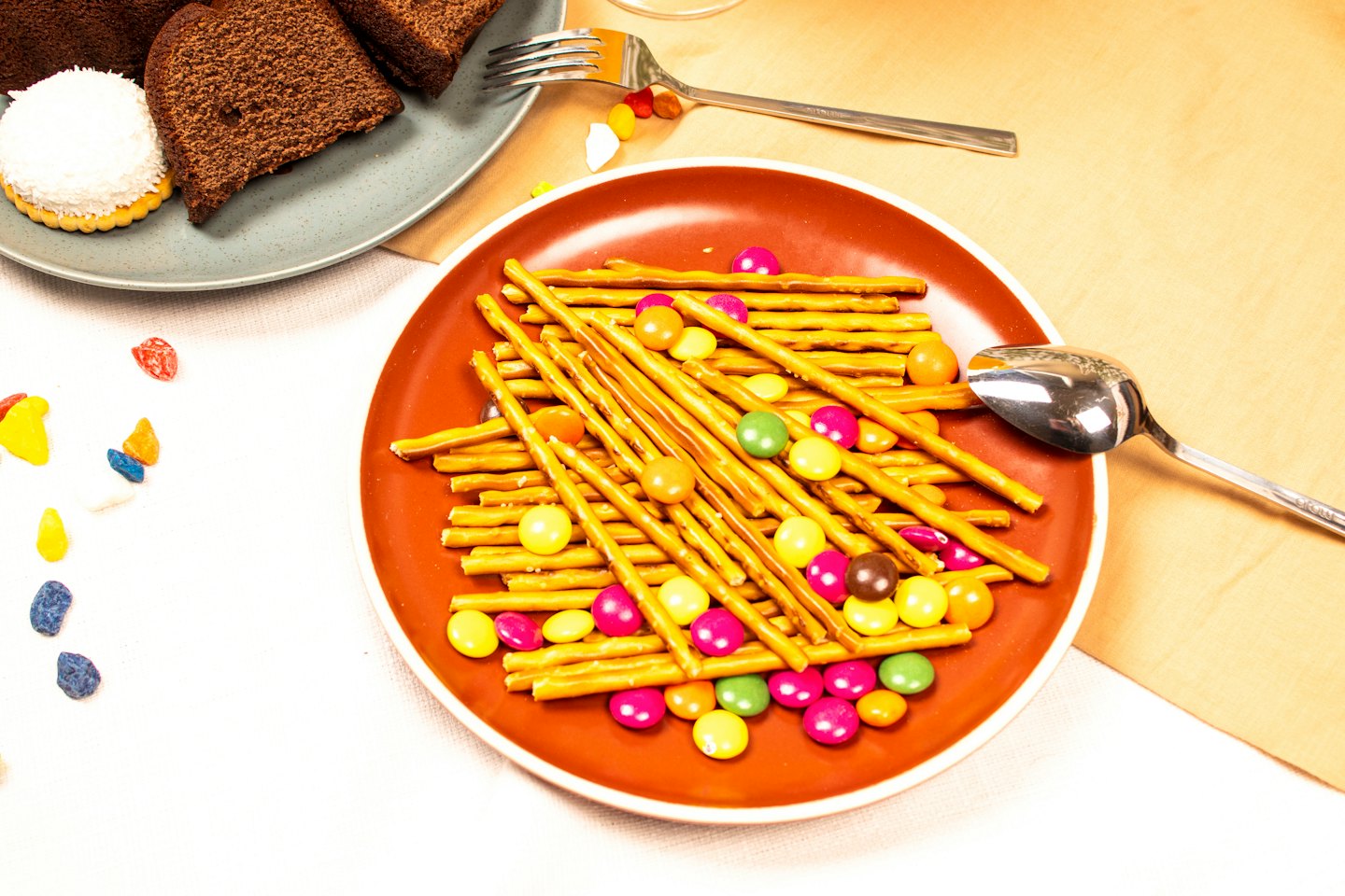 Bocadillos para fiesta y pastel de chocolate sobre un mantel.